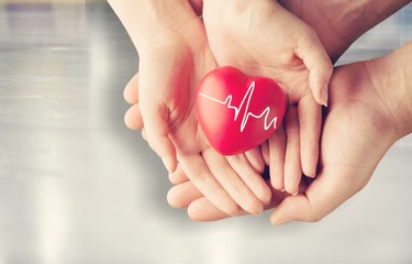 Man and woman holding red heart