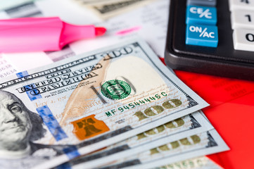 Business and financial background with dollars, data, pen and calculator. Bookkeeping background.