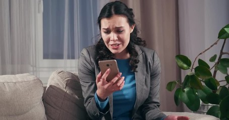 Worried businesswoman talking through video call on mobile phone