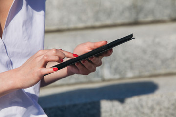 Close-up of female hands typing on touch screen of digital tablet pc