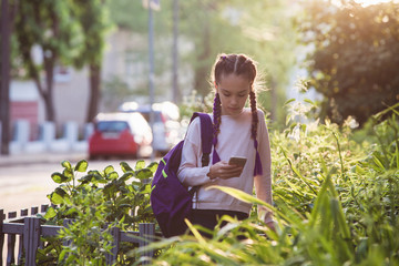 Child is walking with smartphone at sunset