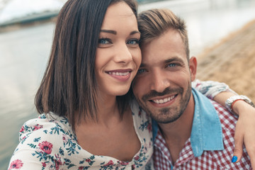 Close up portrait of young couple outdoor looking at camera.