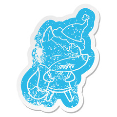 cartoon distressed sticker of a wolf showing teeth wearing santa hat