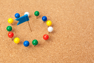 Group of thumbtacks pinned on corkboard