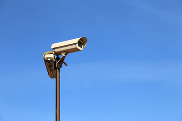 Outdoor surveillance cameras on a pole isolated on clear blue sky. Cctv camera, concept for security, antiterrorism and protection from crime