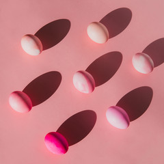 Overhead view of Easter eggs with shadows on pink background