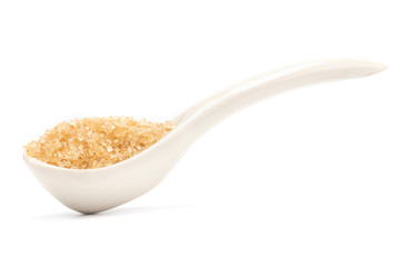 A brown sugar in the ceramic spoon side view