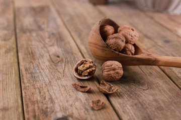 walnuts on a rustic wooden table - close up - walnuts broken up and closed