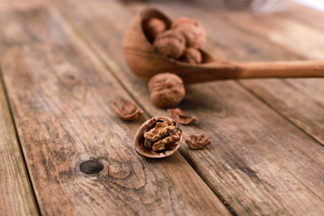 walnuts on a rustic wooden table - close up - walnuts broken up and closed