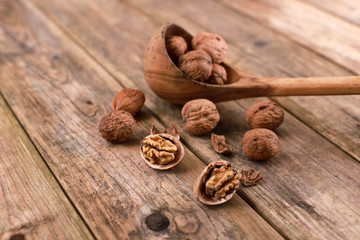 walnuts on a rustic wooden table - close up - walnuts broken up and closed