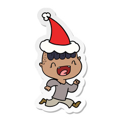 sticker cartoon of a happy boy laughing and running away wearing santa hat