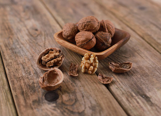 walnuts on a rustic wooden table - close up - walnuts broken up and closed