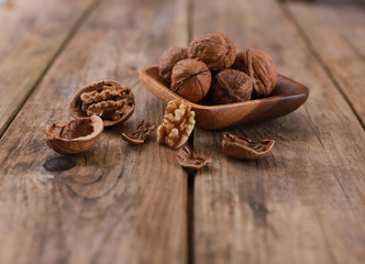 walnuts on a rustic wooden table - close up - walnuts broken up and closed