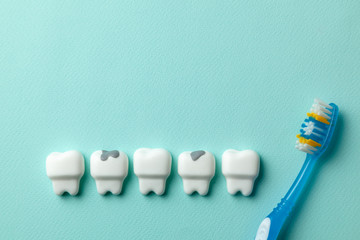 Healthy white teeth and tooth with caries on green mint background and Toothbrush.