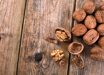 walnuts on a rustic wooden table - close up - walnuts broken up and closed