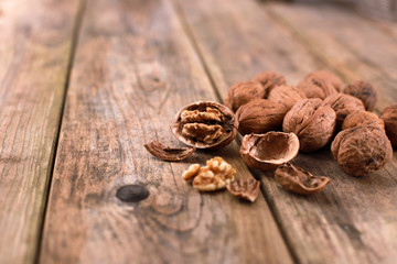 walnuts on a rustic wooden table - close up - walnuts broken up and closed
