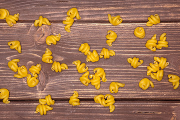 Lot of whole wheat raw pasta funghetto variety flatlay on brown wood