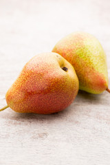 Fresh pears with leaves in a on wooden background.