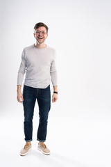 full body picture of a smiling casual man standing on white background.