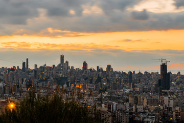 Fototapeta na wymiar This is a capture of the sunset in Beirut capital of Lebanon with a warm orange color, and you can see Beirut downtown in the foreground with some beautiful cloud in the background
