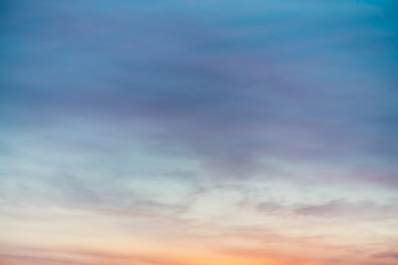 Sunset sky with violet yellow light clouds. Colorful smooth blue sky gradient. Natural background of sunrise. Amazing heaven at morning. Slightly cloudy evening atmosphere. Wonderful weather on dawn.