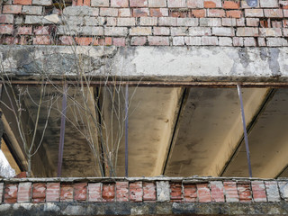 Abandoned old industrial building front without windows, build from brick and concrete.