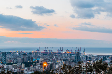 This is a capture of the sunset in Beirut capital of Lebanon with a warm orange color and cool tone cloud and you can see Beirut port in the picture.