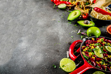 Cinco de Mayo food.Mexican food concept background with taco, quesadilla, burrito, chili, salsa sauce, hot pepper, lime. Black concrete background top view copy space