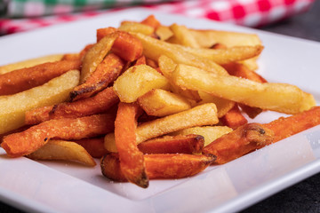 Variety of potatoes for garnish: french fries and sweet potato on a plate