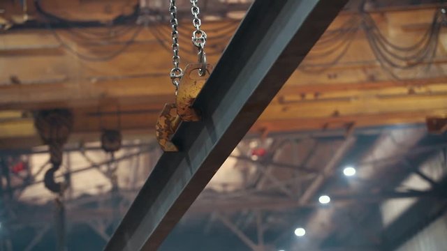 Industrial concept. A crane hook hanging on a chain holding an industrial detail