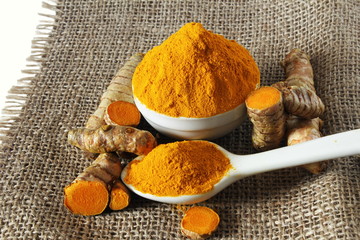 turmeric or curcumin longa powder in bowl and spoon with root isolated 