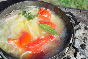 Shurpa soup in cast-iron cauldron outdoor. Food for hike.