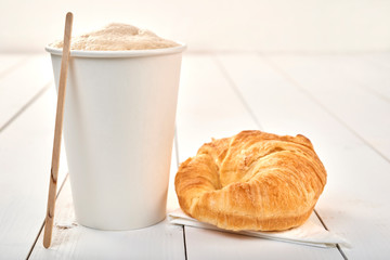 Coffee with croissant on a wooden table
