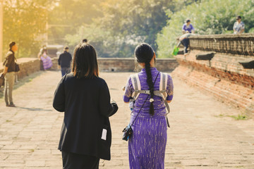 Fototapeta premium Backview of female tourists at ancient Pa Hto Taw Gyi Pagoda ruins at Mingun city near Mandalay, Myanmar.