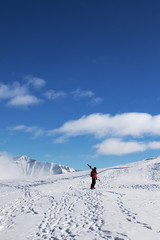 Fototapeta na wymiar Skier with skis on his shoulder and snowy mountain