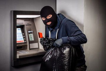 Thief. Hacker stealing money from ATM machine. Phishing, ATM skimming