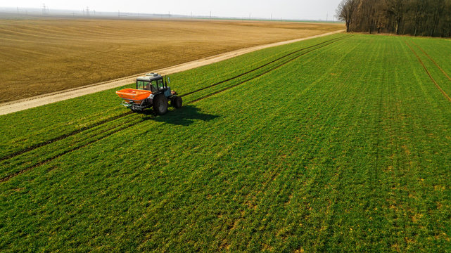 Tractor on a green field. Aerial survey