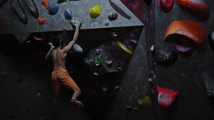 Athletic man practicing in a bouldering gym