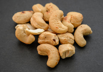 Pile of cashew nuts on dark background.