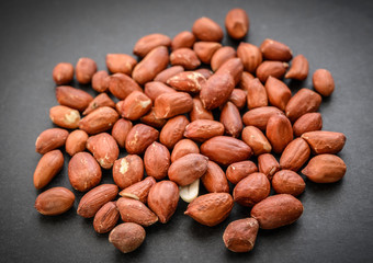 Pile of peanut on dark background.