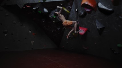 Athletic man practicing in a bouldering gym