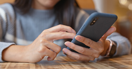 Woman use of mobile phone inside restaurant