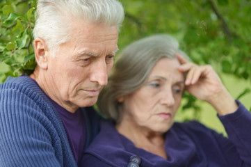 Close-up portrait of sad elder couple outdoor