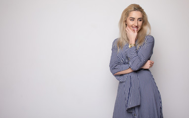 Happy smiling young businesswoman, on grey background. Caucasian blonde model in business concept studio shoot. Blank copyspace area for advertise text or slogan