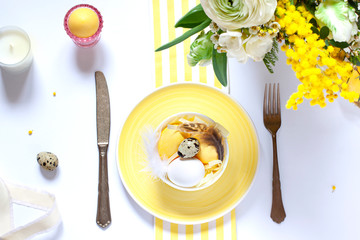 Easter table settings with painted eggs and spring flowers. Top view. Holiday flat lay