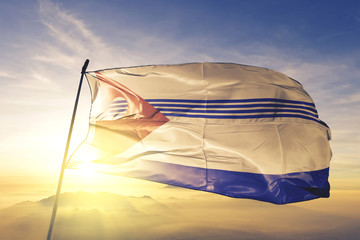 Artigas department of Uruguay flag waving on the top sunrise mist fog