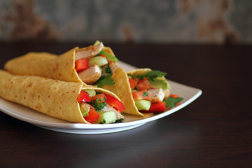 Fresh chicken and salad tortilla wraps on white plate