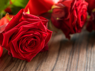 funeral and mourning concept - red rose flower on wooden coffin