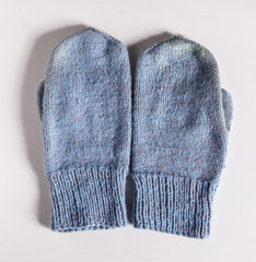Crocheted mittens on white background