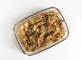 Fried pieces of meat in a glass container on a white background.